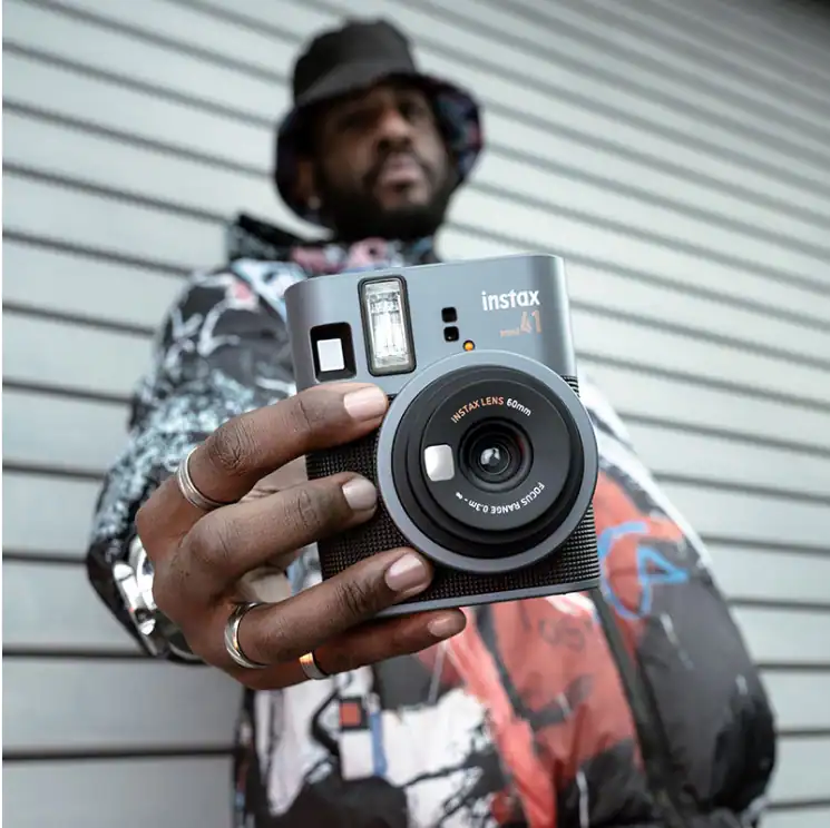 Fujifilm Instax Mini 41 instant camera in Black, in-hand lifestyle shot