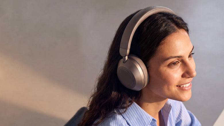 Woman wearing Soundcore Space 2 Pro headphones in metallic taupe, official Anker press image