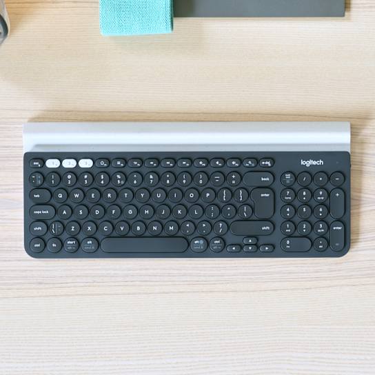 Logitech K780 keyboard paired with a phone in its integrated cradle