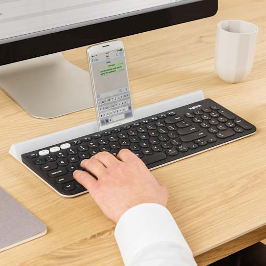 Logitech K780 keyboard in use on a desk with tablet