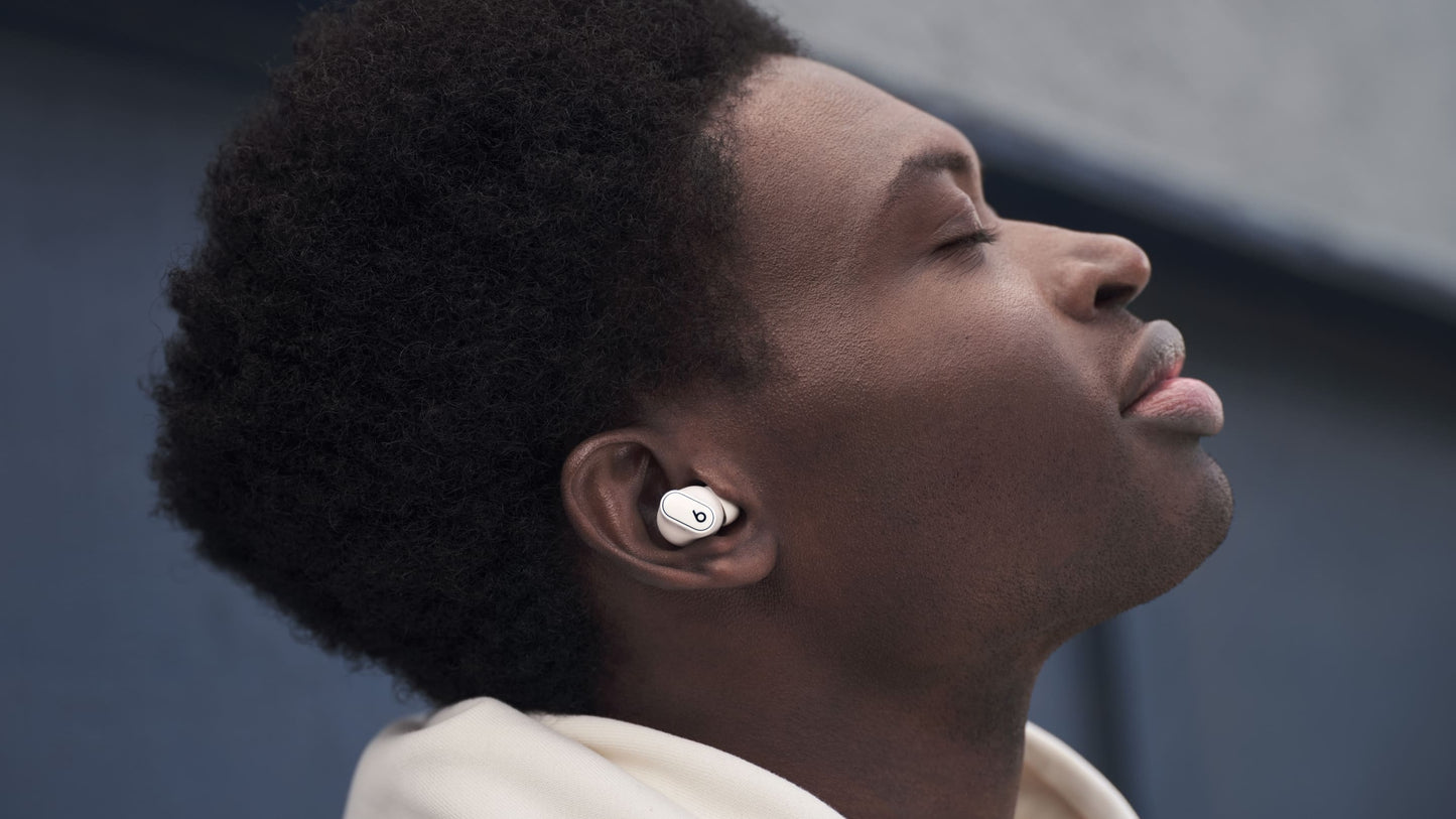 Person wearing Beats Studio Buds Plus earbuds in Ivory